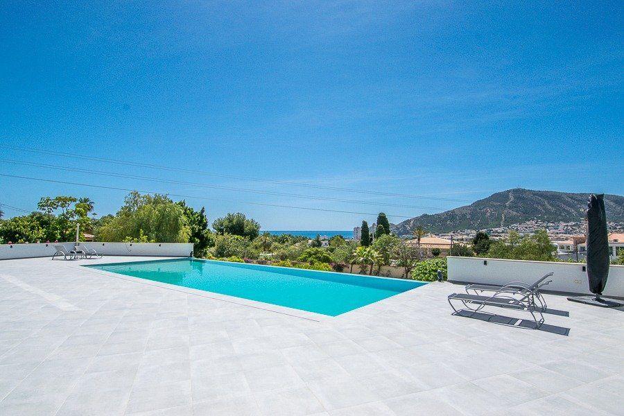 913DA - Villa moderne entièrement rénovée avec vue panoramique sur la mer, piscine à débordement et court de tennis.