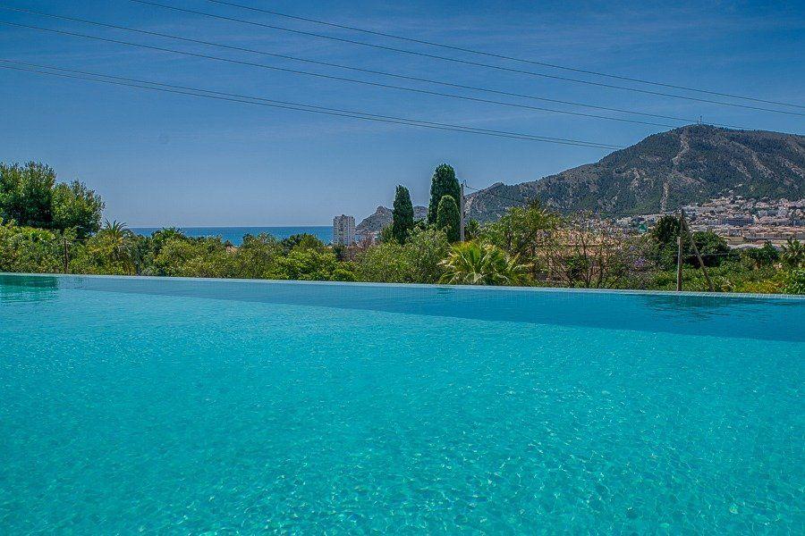 913DA - Villa moderne entièrement rénovée avec vue panoramique sur la mer, piscine à débordement et court de tennis.
