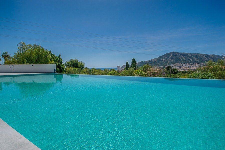 913DA - Villa moderne entièrement rénovée avec vue panoramique sur la mer, piscine à débordement et court de tennis.