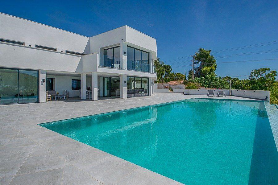 913DA - Villa moderne entièrement rénovée avec vue panoramique sur la mer, piscine à débordement et court de tennis.