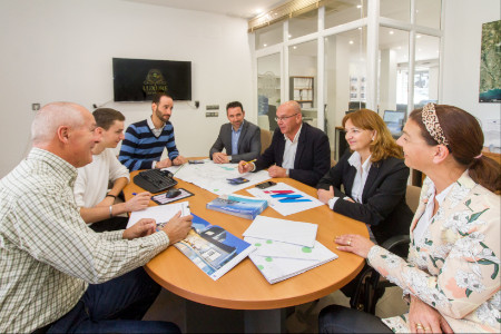 Team of expert real estate agents in Moraira sitting around meeting table
